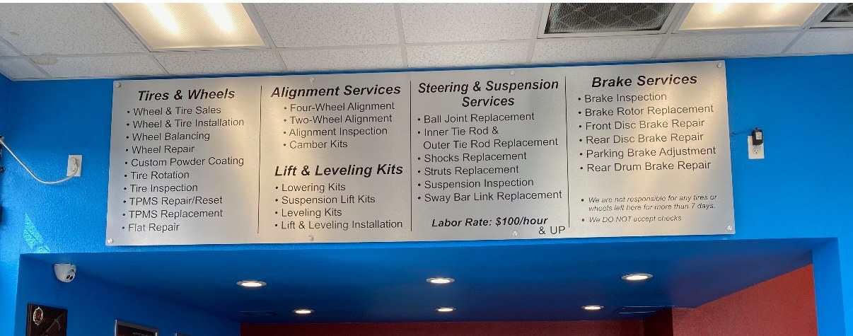 Expert Tire & Auto Service menu board listing tire, alignment, lift, suspension, and brake services